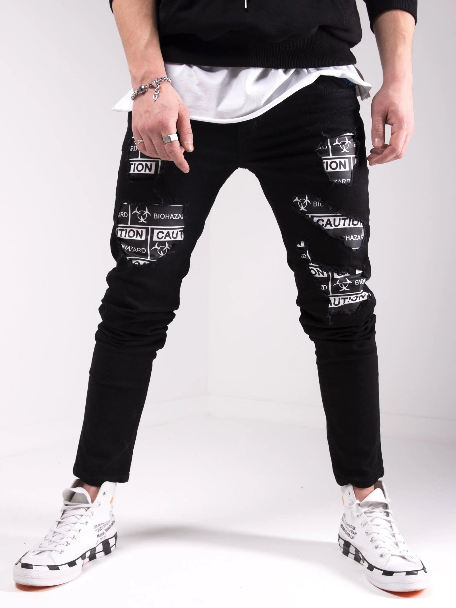 A man wearing BLACKOUT BIOHAZARD jeans and a white t-shirt.