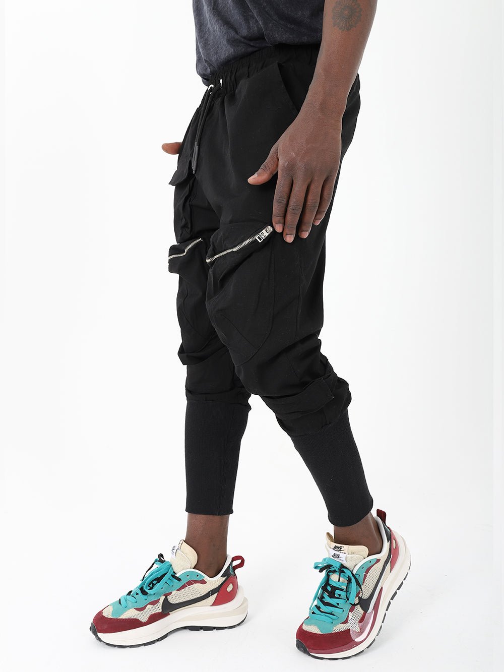 A man wearing black Mereen joggers and sneakers.