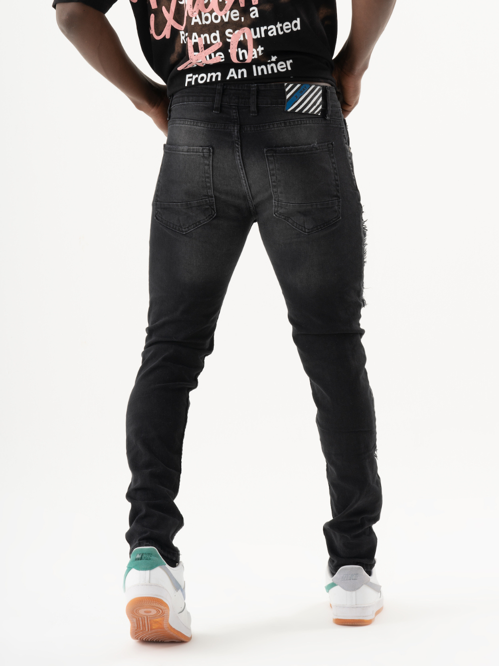 The back of a man wearing ONE SOUL jeans and a t - shirt.
